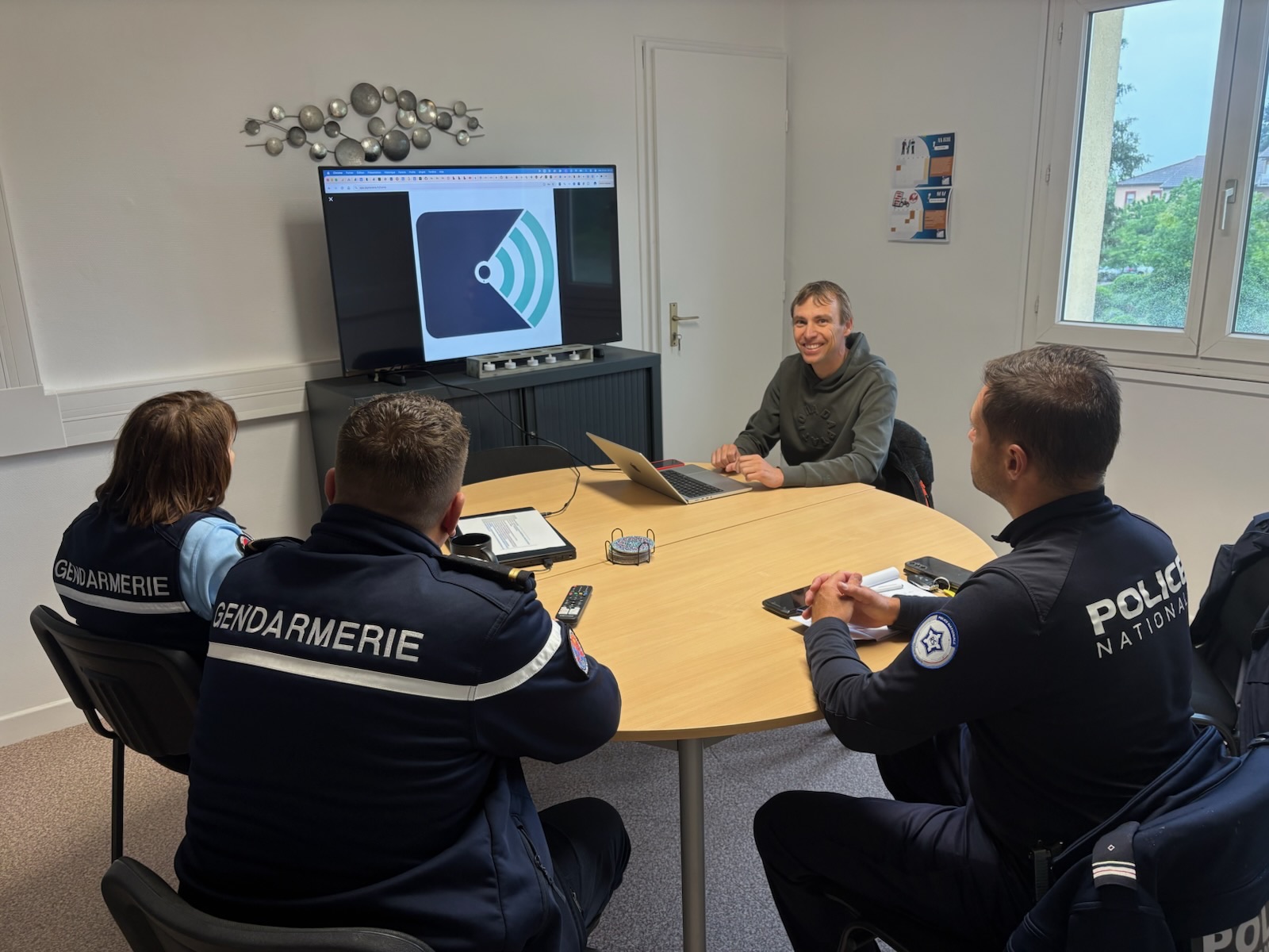 Roméo Roy presenting JePréviens to police and gendarmerie officers around a meeting table